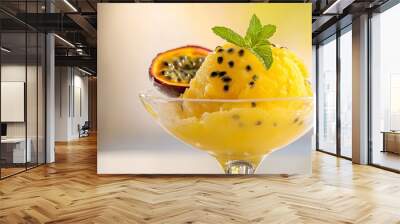 A vibrant scoop of passion fruit sorbet is artfully displayed in a clear glass bowl, garnished with a few fresh passion fruit seeds and a sprig of mint. The bowl rests on a clean white surface, which Wall mural