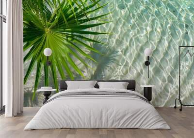 Palm tree leaves on very clear and transparent water, with a concept of an overseas vacation spot. Wall mural