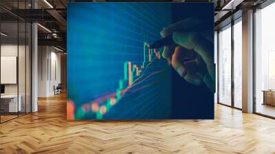 Closeup hand pointing pen on blue color monitor to analyze stock market graph Wall mural