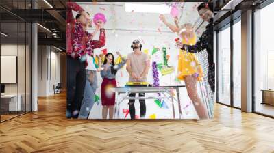 group of happy friends dancing and drinking alcohol or cocktail in new year party with booth dj and throwing confetti .Young people celebrating and laughing with music festive holidays Wall mural