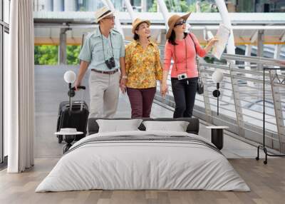 group of three happy asian Senior  tourists walking in urban city outdoors.  old man Travellers lifestyle  . elderly women vacation . ageing society concept. pensioner traveling . mature Wall mural