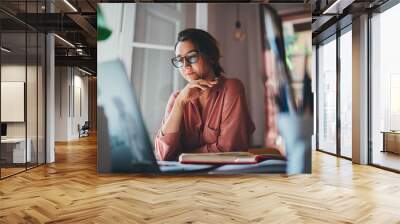 beautiful businesswoman sitting at table opposite laptop in workplace brainstorming new project, peo Wall mural