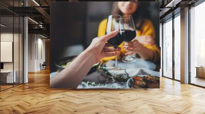 Cropped image of romantic couple making cheers with glasses of red wine during date in restaurant, Love Relationship Celebration Concept Wall mural