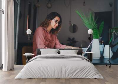 Young female entrepreneur working remotely from a home office using modern laptop computer, woman copywriter working online  Wall mural