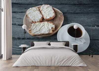 Piece of homemade biscuit cake and coffee on a black wooden table. Wall mural