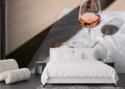 A glass of rose wine with appetizers on a white background. Wall mural