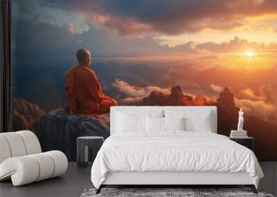 Buddhist monk in meditation on mountaintop at beautiful sunset or sunrise Wall mural