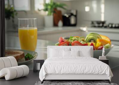 A bright and cheerful scene of a healthy breakfast, featuring a bowl of fresh fruit, a glass of orange juice, and a sandwich on a plate, set on a kitchen counter with natural light streaming in Wall mural