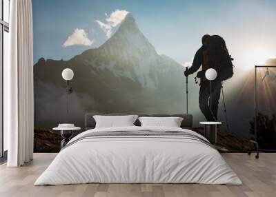 Mountain Man with backpack hiking in the mountains at sunset Wall mural