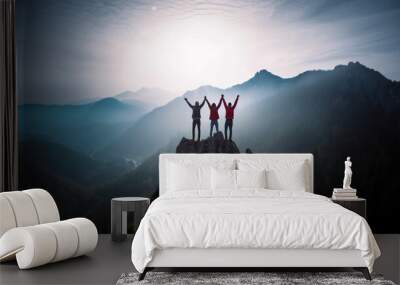 Together overcoming obstacles with three people holding hands up in the air on mountain top , celebrating success and achievements Wall mural