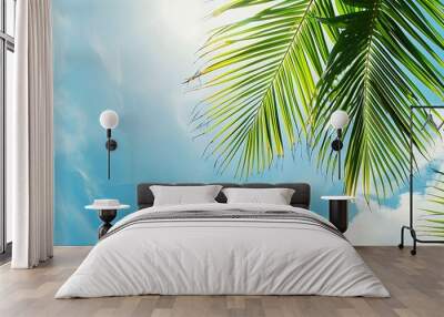 Vertical up view of palm leaves with blue sky Wall mural