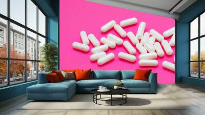 Capsules in pink and white on a. Pill capsule drug concept. A white and pink with capsules of medicine. A white and pink with capsules of medicine lifestyle. Wall mural