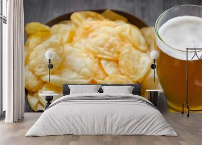 chips with beer. on a wooden table there is a transparent plate with chips next to it there is a large mug with beer, relaxation concept Wall mural