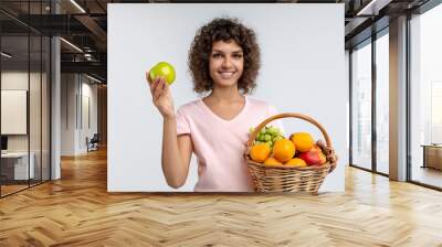 Girl is eating food in basket with fruit. grocery happy people concept. a girl in white with a basket of fruit on the . a girl is eating food in a basket lifestyle of white fruits. Wall mural