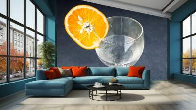 water with orange. there is a glass of water and a slice of orange on a blue table, top view close-up drink concept Wall mural