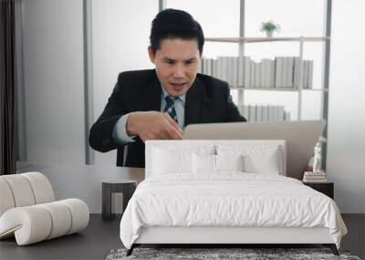 Businessman having video call via laptop in the office Wall mural