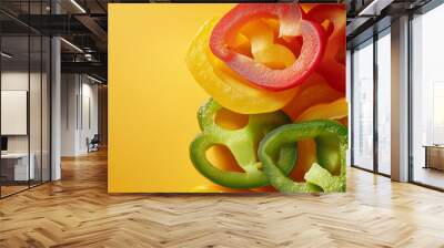 a plate of bell pepper slices in red, yellow, and green against an isolated warm-toned background Wall mural