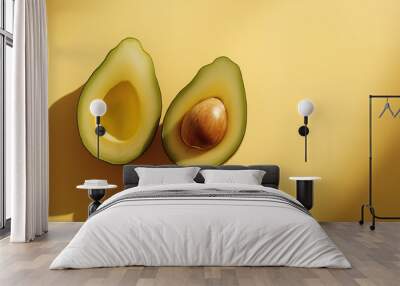 a ripe avocado cut in half with the pit still inside against an isolated warm-toned background Wall mural