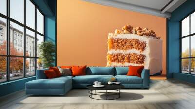 a slice of carrot cake with cream cheese frosting and a sprinkle of chopped walnuts against an isolated warm-toned background Wall mural