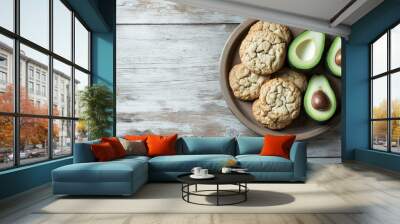 avocado as a butter alternative: a clean, minimalist photograph of cookies, arranged on a simple wooden plate with a whole and half-cut avocado nearby Wall mural