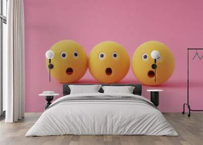 emotional, mood, surprise concept: three yellow balls with surprised faces arranged in a scattered, dynamic pattern against an isolated baby pinksoft pink background Wall mural