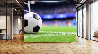 close up view of soccer ball positioned near goalpost, with blurred stadium background filled with spectators. vibrant green grass enhances excitement of game Wall mural