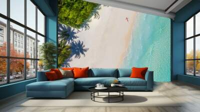 Aerial view of a woman relaxing on tropical beach Maldives islands. Vacation adventure aerial beach landscape, turquoise water, soft sand. Amazing top view from drone beach shore azure lagoon seaside Wall mural