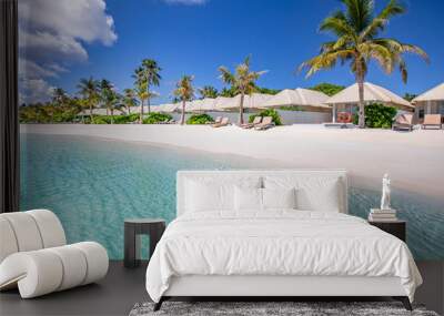 Beach villas in Maldives, luxury summer travel and vacation background. Amazing blue sea and palm trees under blue sky. Tropical landscape and exotic beach. Summer holiday or honeymoon destination
 Wall mural