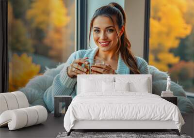 Beautiful woman leisure in nightwear lingerie sitting in bed with cup of coffee. Beautiful autumn morning light from window colorful leaves background. Charming happy girl enjoying sunlight. AI gen Wall mural