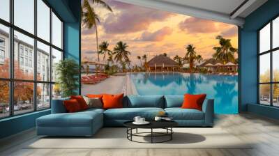 Fantastic panoramic poolside, sunset sky, palm trees. Luxury tropical beach landscape, infinity swimming pool, deck chairs loungers under umbrellas amazing scenic. Vacation resort hotel landscape Wall mural