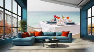 Fresh breakfast in a beautiful location with sea views. Luxury summer vacation or honeymoon destination. Table with gourmet delicious food near the sea with horizon. Beautiful summer breakfast setting Wall mural