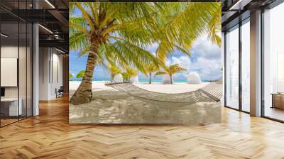 Hammock between two coconut trees on a tropical island with beautiful beach. Luxury lifestyle, summer travel background Wall mural