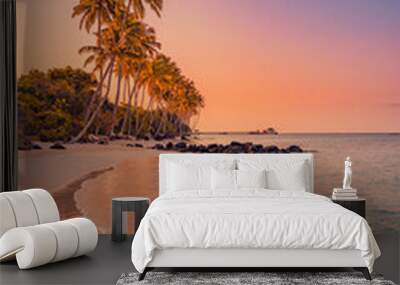 Palm trees on sandy island close to ocean. Beautiful bright sunset on tropical paradise beach, relaxing coastal landscape. Exotic scene, closeup sea waves. Evening colorful sky, peaceful seascape Wall mural