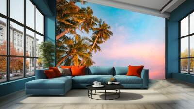 Romantic vibes of tropical palm tree sunlight on sky background. Outdoors sunset exotic foliage, closeup nature landscape. Coconut palm trees and shining sunrise over bright sky. Summer inspire nature Wall mural