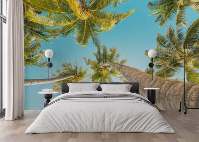 Tropical palm trees background. Coconut palms and peaceful inspire blue sky. Exotic summer nature pattern panorama, green leaves, natural landscape. Summer travel tropical island, panoramic vacation Wall mural