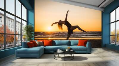 Silhouette of a happy dancer girl jumping the sunset Wall mural