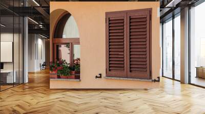 The window with red flowers and blind shutters Wall mural