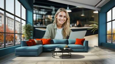 happy young woman, smiling girl student using laptop computer sitting on chair in cafe space working online Wall mural