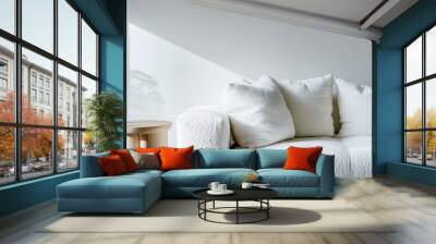 Minimalist interior with a white textured sofa and soft pillows,  light wooden side table, cozy living space Wall mural