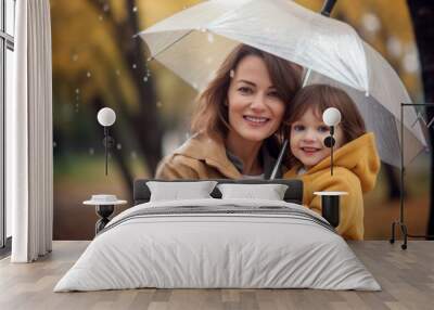 mother with her son under an umbrella enjoying the rainy autumn weather in the park Wall mural