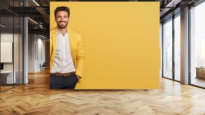 portrait of smiling handsome confident male businessman entrepreneur with hands in pockets on yellow background, advertising promotion banner Wall mural