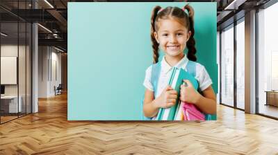 portrait of smiling schoolgirl isolated on teal background, back to school concept Wall mural