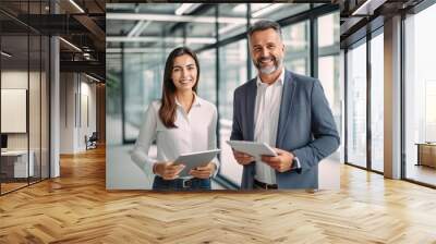 smiling two professional business people standing in office with with digital tablets Wall mural