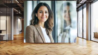 Successful Hispanic Latin senior businesswoman in her 40s, confidently standing and smiling proudly, mature and good-looking middle-aged leader in an office Wall mural