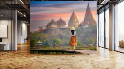 young farmer woman walks on wooden bridge terrace of rice to the temple at morning sunrise with scenerry view of buddhist temple pagoda in background Wall mural