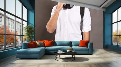 Young man dressed in white shirt and with headphones Wall mural