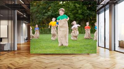 Happy Kids Having Potato Sack Race Outside Wall mural