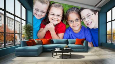 Happy Kids Sitting Together in Grass Outside Wall mural