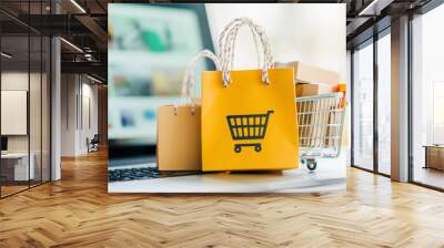 A laptop screen shows a shopping cart with two shopping bags on top of it Wall mural