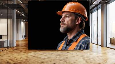 A construction worker man with a beard wearing an orange hard hat and a plaid shirt , looking serious against a dark background  Wall mural